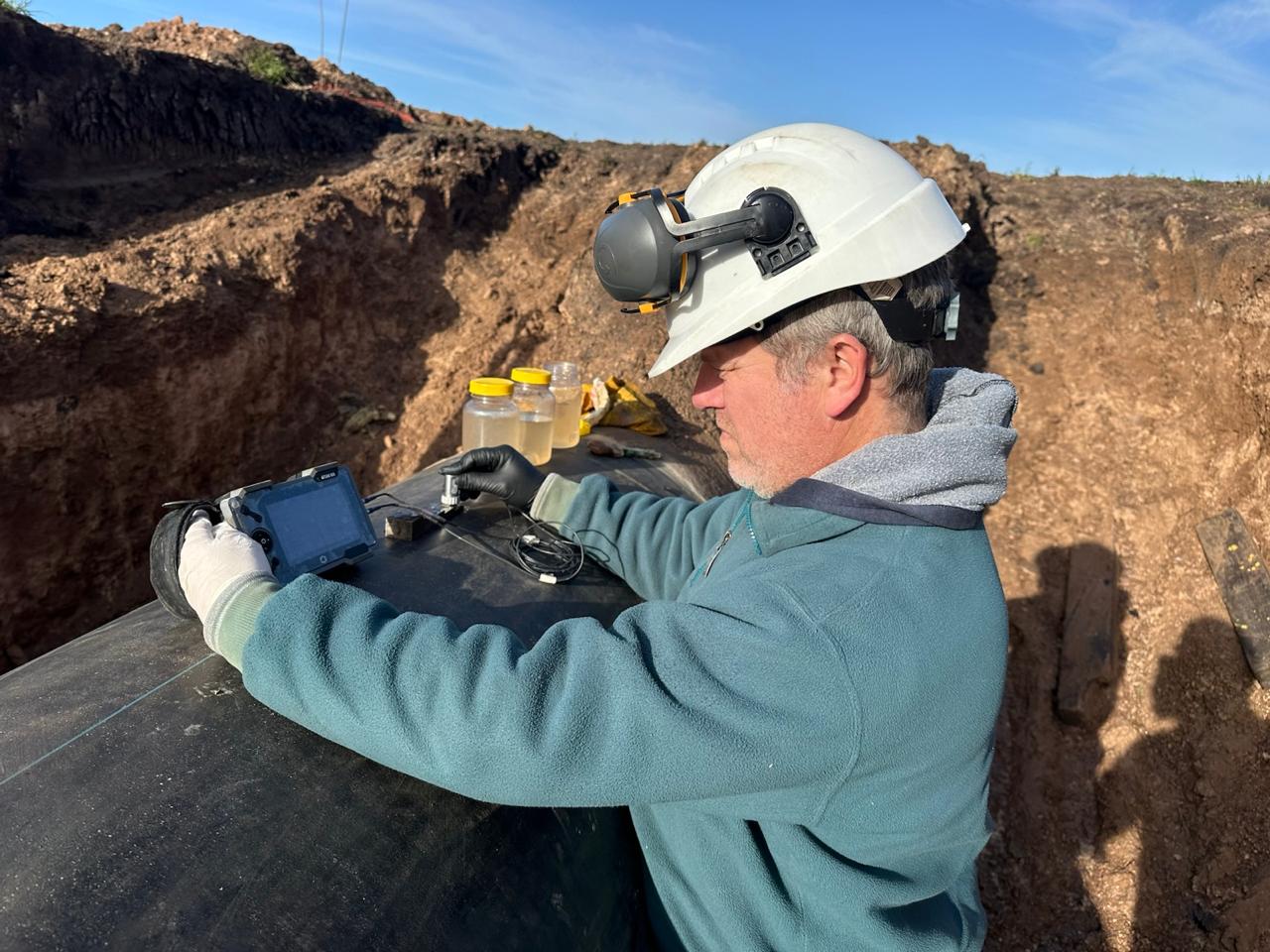 Operador realizando una inspección por ultrasonido sobre una tubería en campo